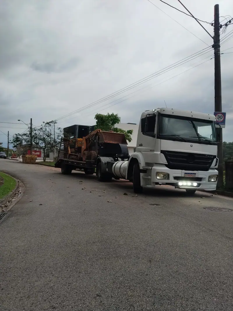 Caminhão transportando uma máquina pesada em uma rua